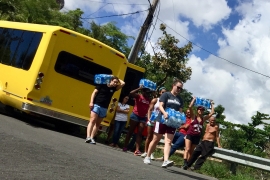 students carrying supplies from a bus
